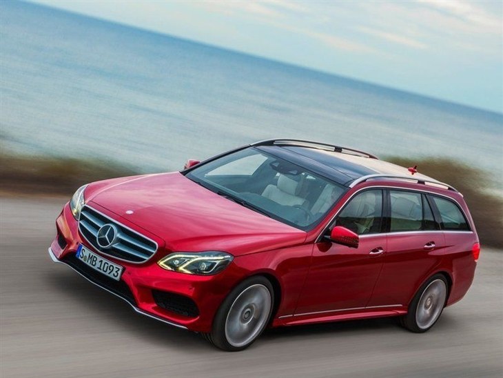 A Side View of a Mercedes Benz E Class Estate in Red driving