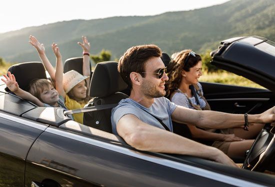 arefree family having fun during road trip by convertible car