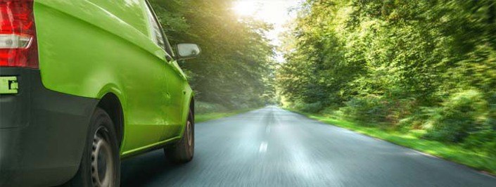 green van driving down a country road