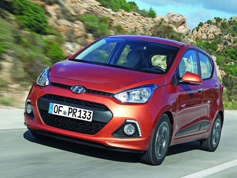 exterior of a red hyundai i10 driving on the road