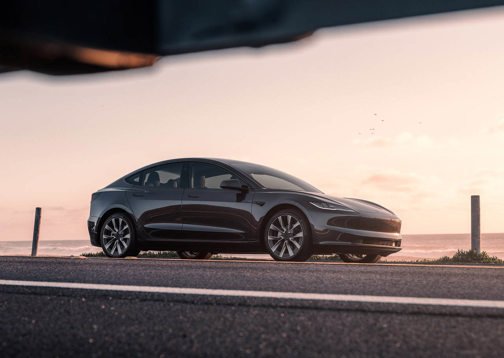 Tesla Model 3 with sun setting in the background