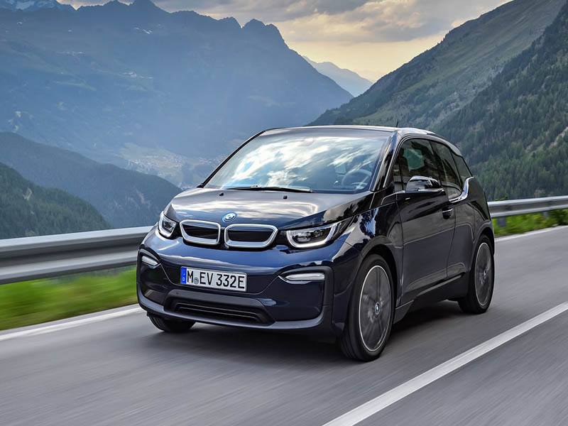blue bmw i3 electric car driving on mountain road