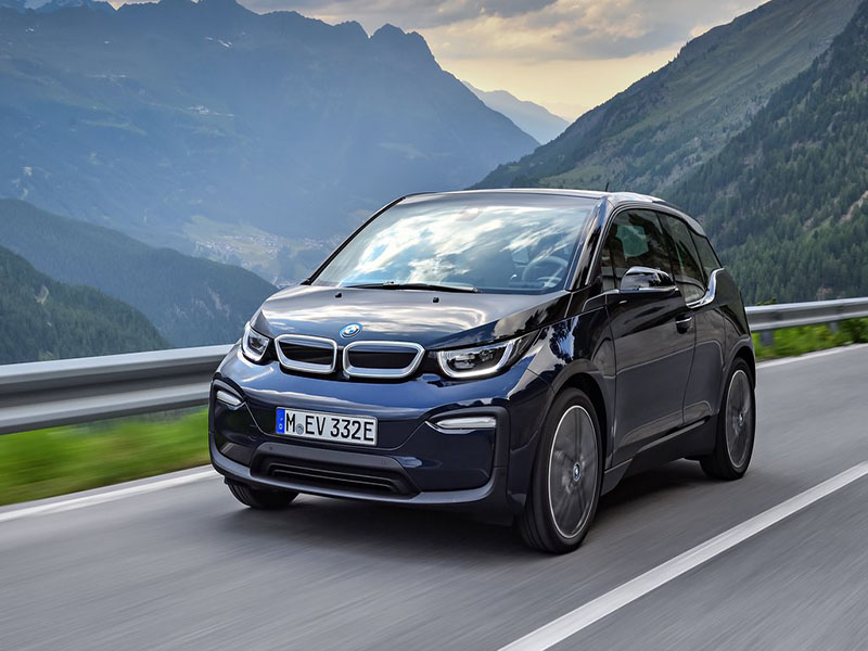 blue bmw i3 driving on open road