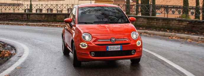 red fiat 500 city car driving on road