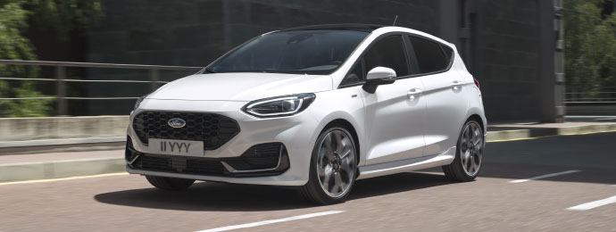 white ford fiesta supermini driving on road
