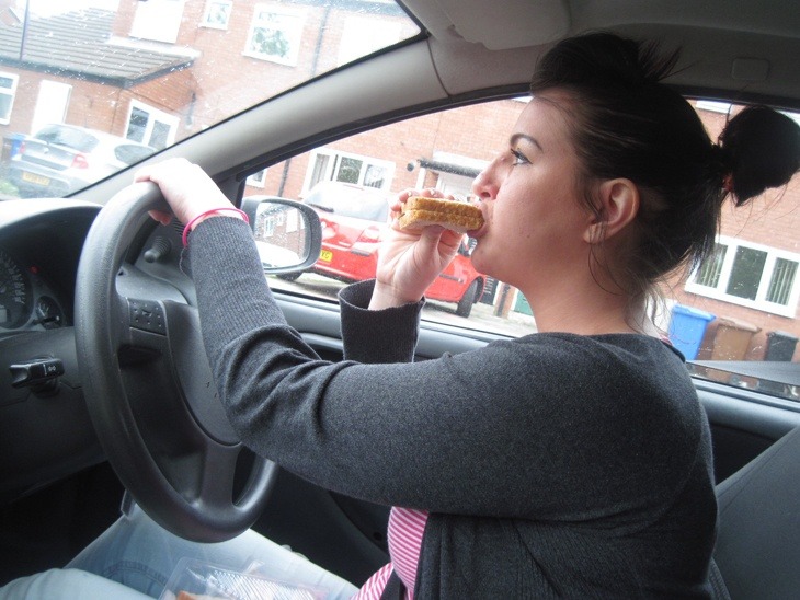 Girl eating whilst driving (posed)