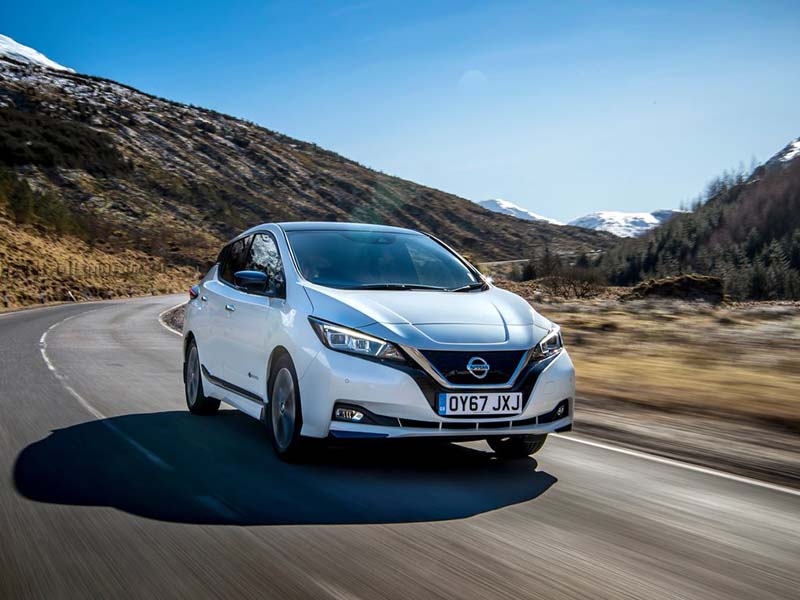 white nissan leaf driving on open road