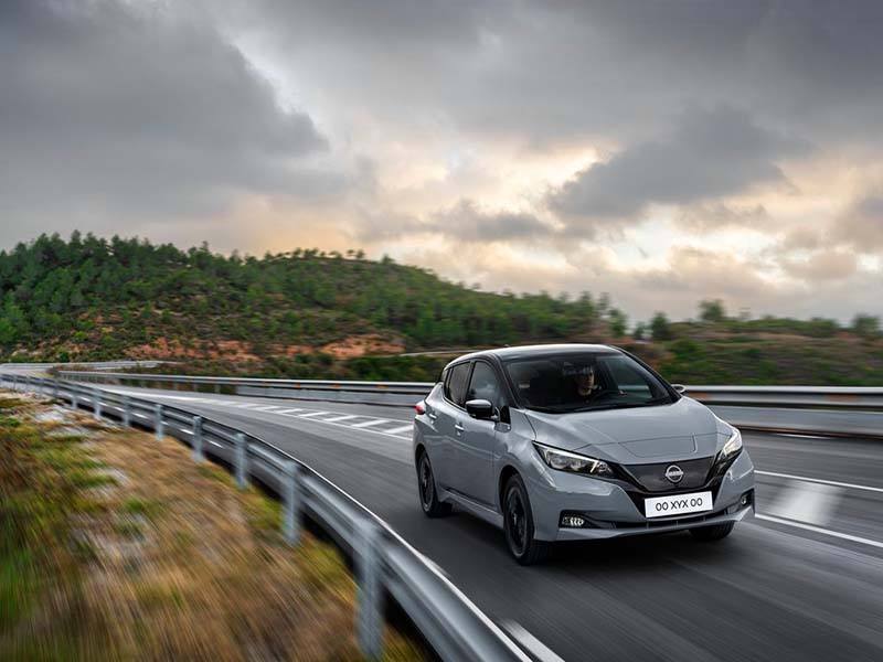 grey nissan leaf driving on country road
