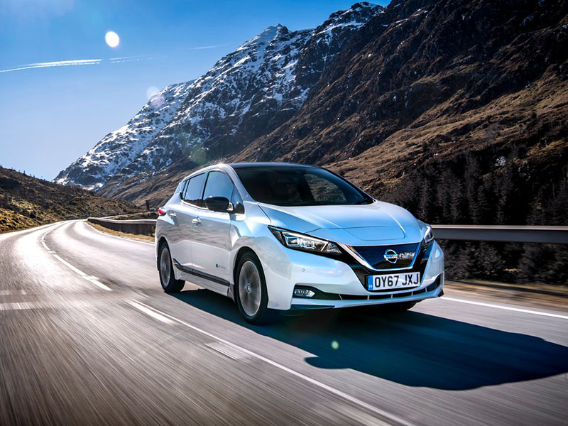 white nissan leaf driving on open road