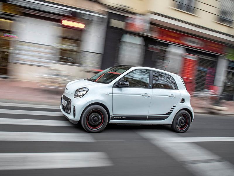 white smart forfour hatchback driving down city street