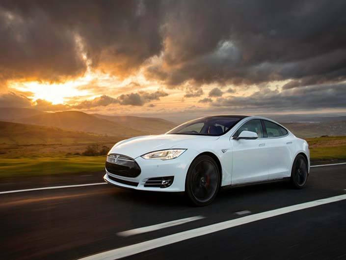A white Tesla Model S driving on the road