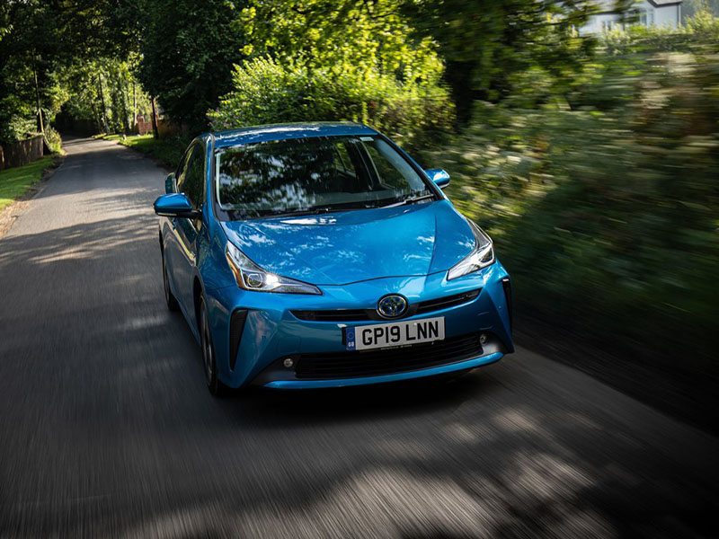 blue toyota prius driving on country road