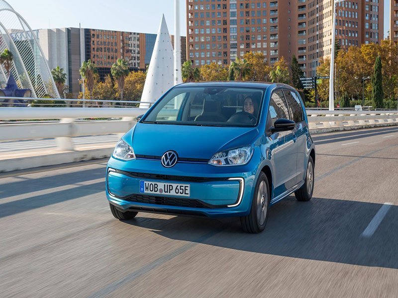 blue volkswagen e-up driving on road