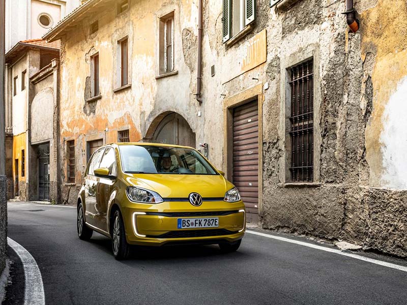 yellow volkswagen e-up driving on Italian street