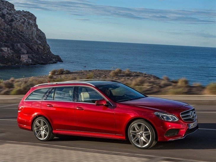 A Side View of a Mercedes Benz E Class Estate in Red driving