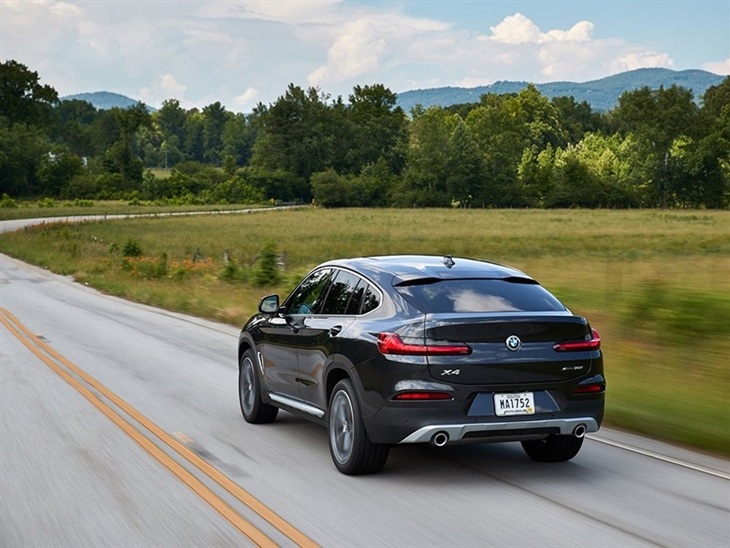 BMW X4 2019 Promo driving rear left view in dark metal highway road