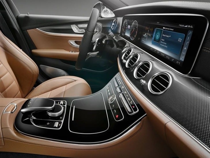 A view of the Drivers Seat, the Steering Wheel and center console in a Mercedes Benz E Class Saloon