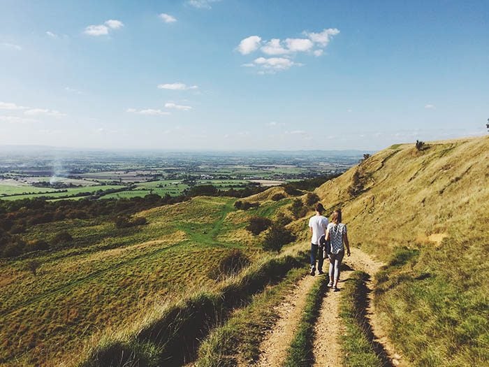 man and woman walking in the cotswolds