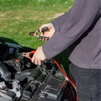 person in grey longsleeve shirt jump starting car