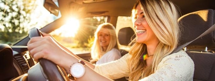 Young womman driving with her mother in her first leased car