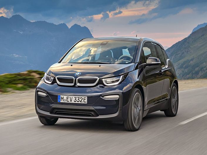 black bmw i3 driving with mountains in the background
