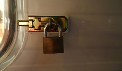 a brass padlock secures a metal latch