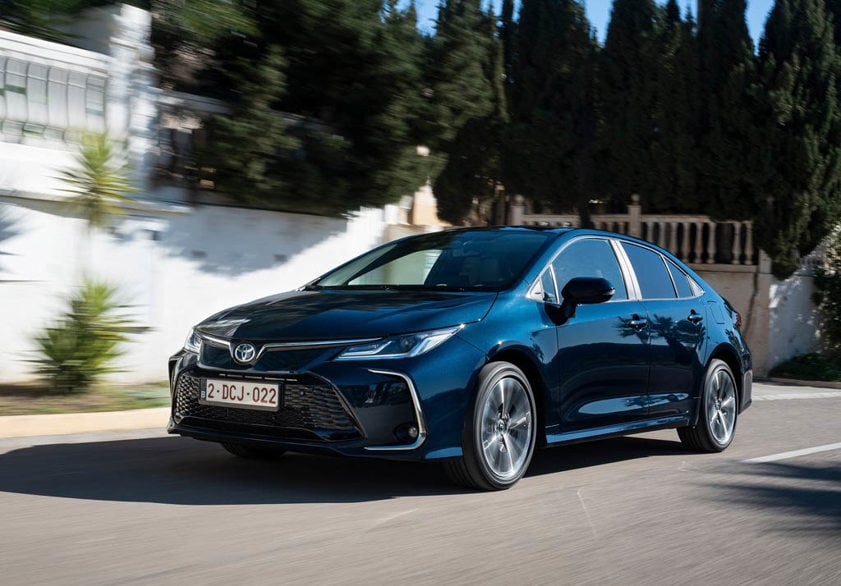 Blue toyota corolla driving on the road