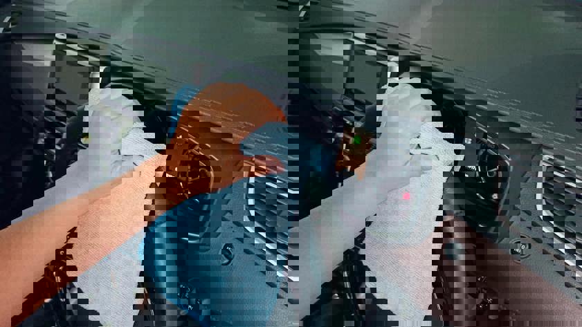 Cleaning a car steering wheel with a blue cloth