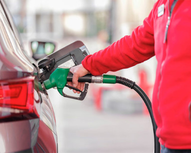 Person in red jacket refuelling a car