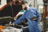 Professional mechanic examining a car in a garage