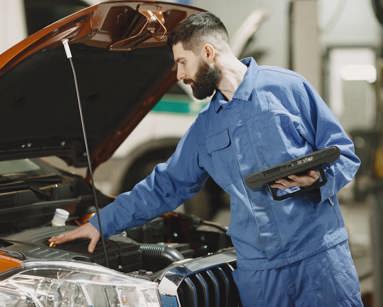 Professional mechanic examining a car in a garage