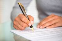 man signing finance documents