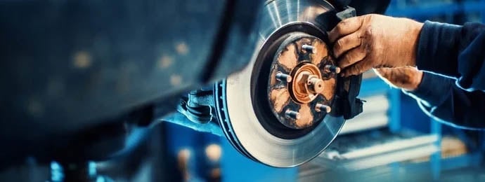 A mechanic adjusting car parts in a garage