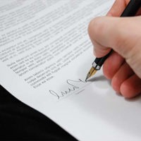 close up of person signing a document