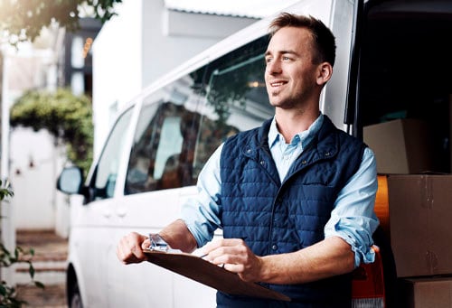 Shot of a courier checking his deliveries in his van