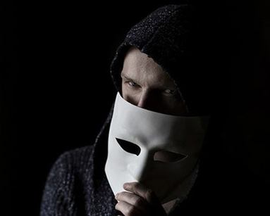 Close up of scammer hiding behind a mask.
