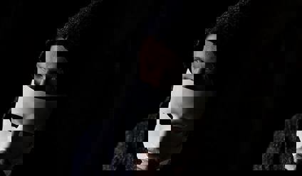 Close up of scammer hiding behind a mask.