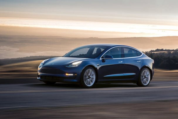 Blue Tesla Model 3 driving on the road 
