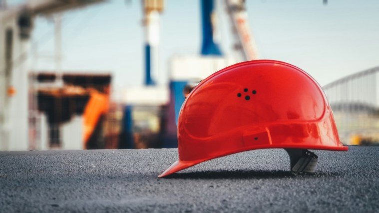 Red hardhat in front of construction site