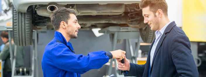 Mechanic handing car key to customer at a garage