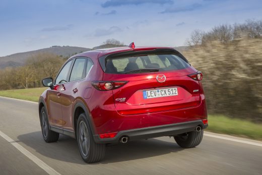 Rear view of Mazda CX-5 in red driving on road