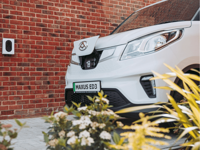 A white maxus van plugged into charge