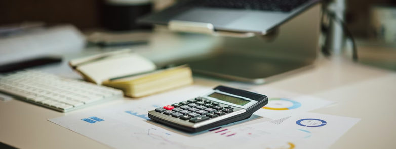 a calculator sitting on top of a table next to a laptop