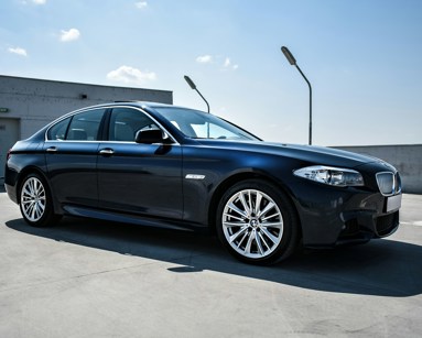 Black BMW Saloon car from side on with silver alloy wheels