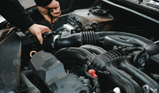 Close-up of a mechanic working on a car engine.