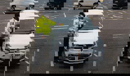 parking attendant putting fine on car