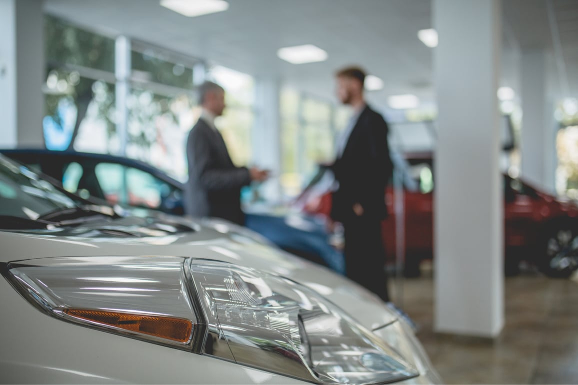 Auto showroom, dealer talking with buyer