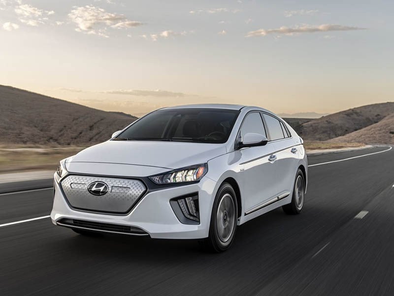 white hyundai ioniq electric driving on the road