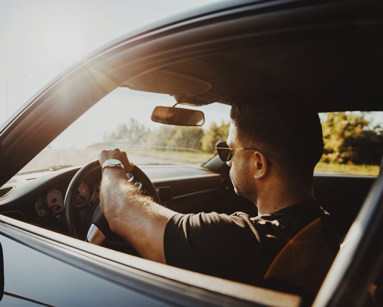 Men driving lease car in sunset