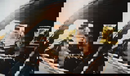 Men driving lease car in sunset